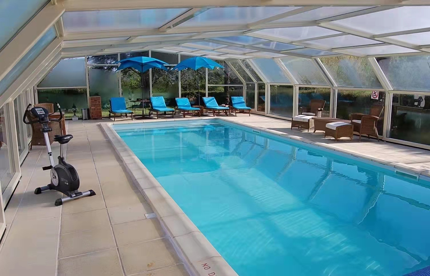 retractable pool enclosure covering indoor swimming pool with aluminum frame and polycarbonate roof