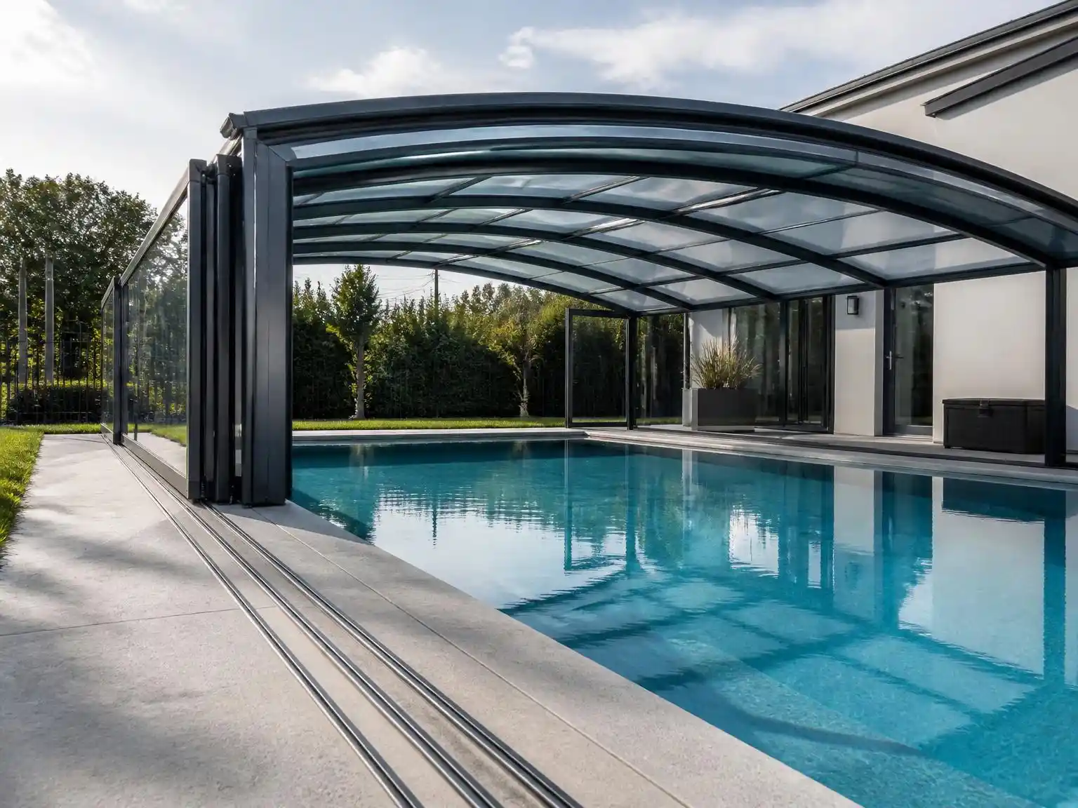 aluminum retractable pool enclosure covering an outdoor swimming pool