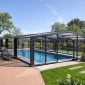 modern retractable pool enclosure covering backyard swimming pool with telescopic aluminum structure