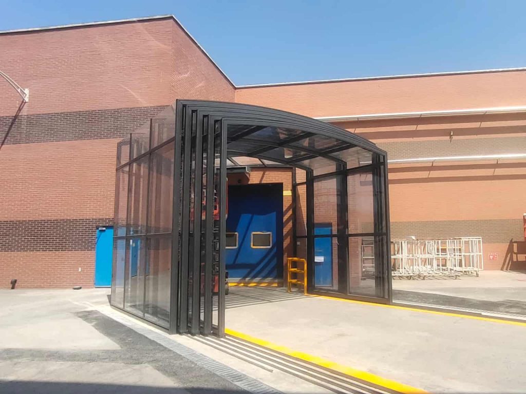Glass walkway enclosure connecting factory buildings in an industrial facility