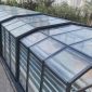 Glass pool enclosure with curved roof structure for an outdoor private pool
