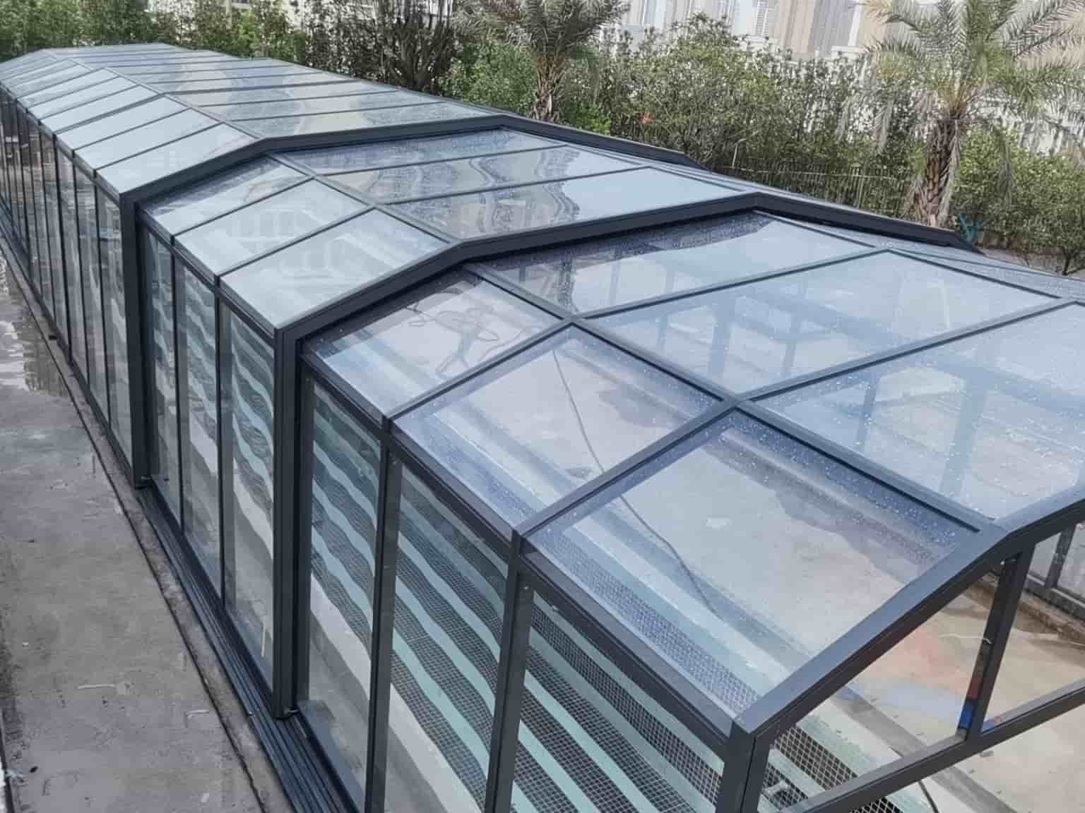 Glass pool enclosure with curved roof structure for an outdoor private pool