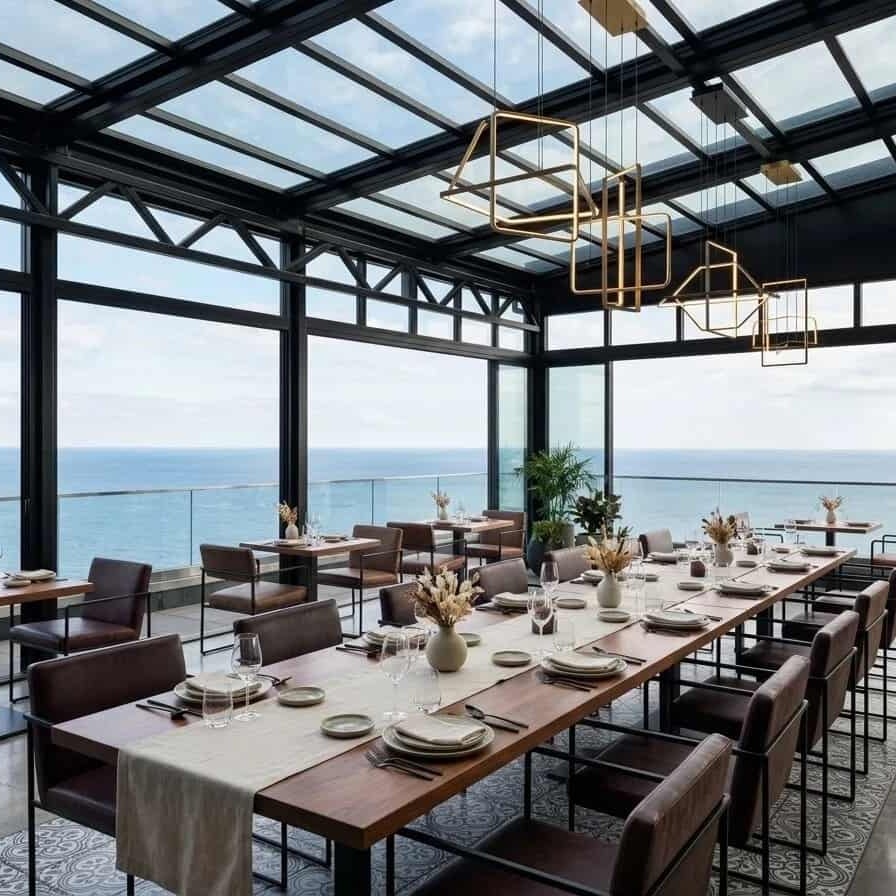A retractable glass roof system creates a flexible seaside dining and event space with natural views.