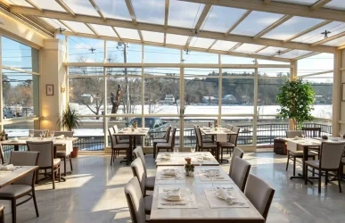 Restaurant glass enclosure with retractable roof for weather-protected outdoor dining