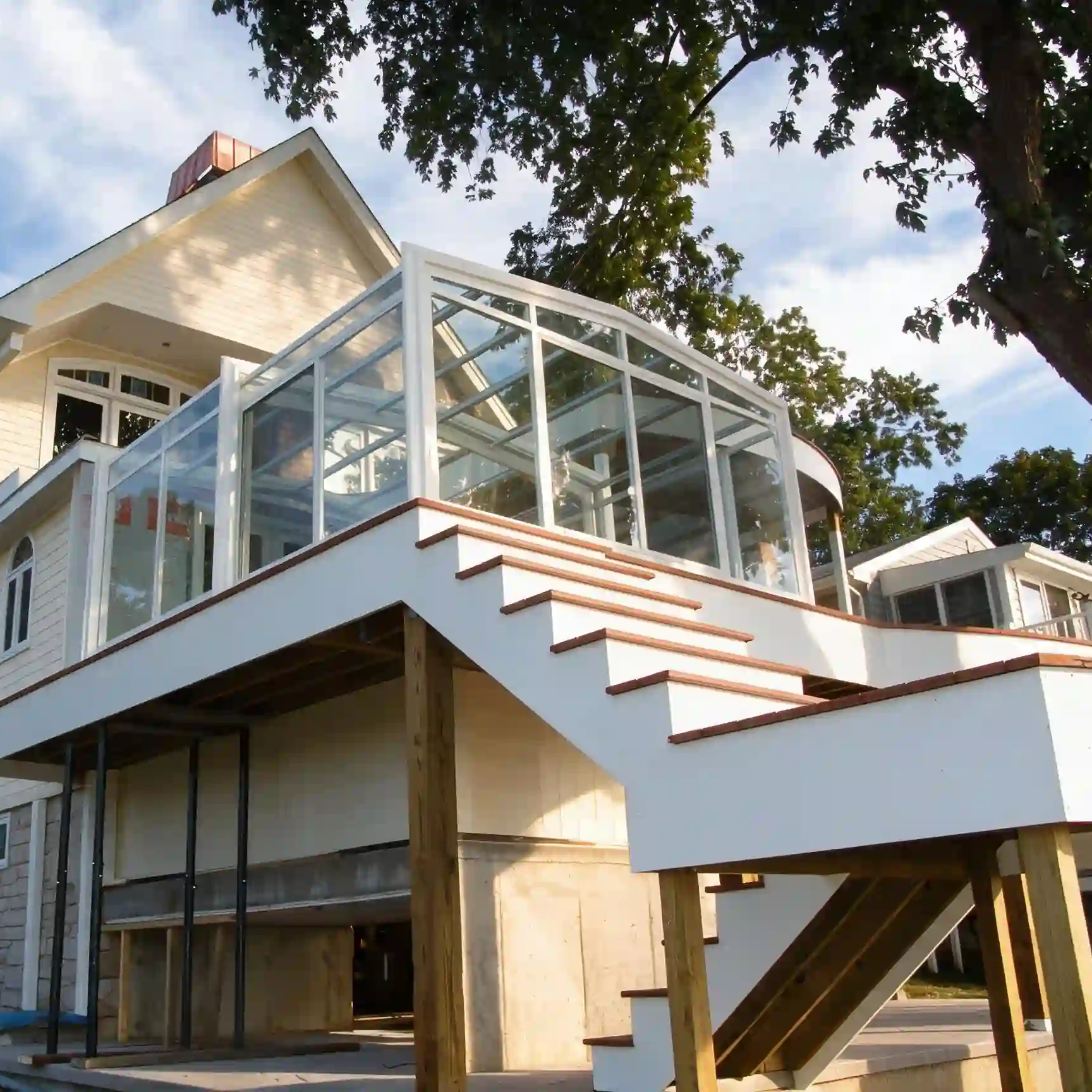 Retractable glass sunroom for residential terrace with clear roof panels and aluminum frame