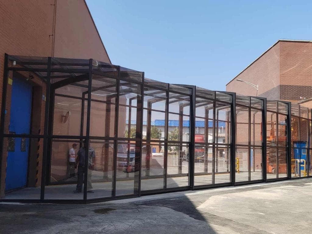 Industrial glass walkway enclosure connecting factory buildings