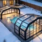 Pool enclosures with warm lighting in a snowy winter evening backyard