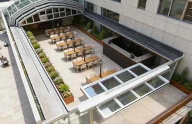 Motorized retractable roof for restaurant patio with outdoor seating